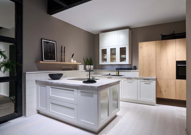 Moderne Küche im Landhausstil von Häcker Küchen mit Kochinsel und weißen Paneelfronten erhältlich bei KÜCHE kreativ