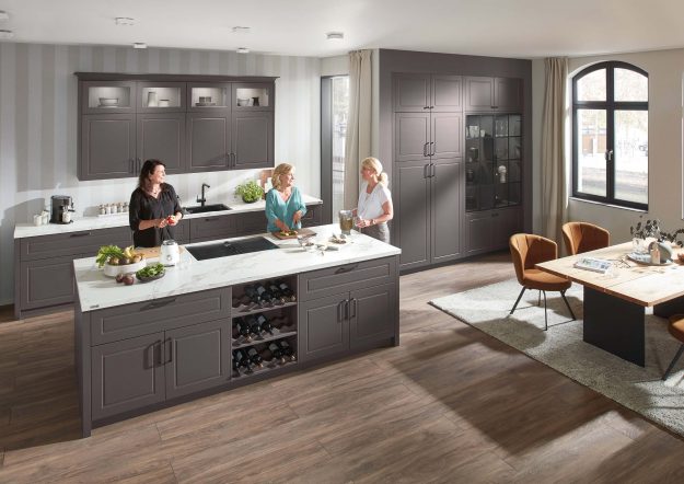 Graue Inselküche im Landhausstil von Ballerina Küchen mit Metallgriffen und Regalelementen erhältlich bei KÜCHE kreativ