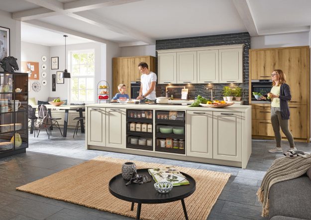 Beige Inselküche im Landhausstil von Ballerina Küchen mit Metallgriffen und offenen Auszügen erhältlich bei KÜCHE kreativ